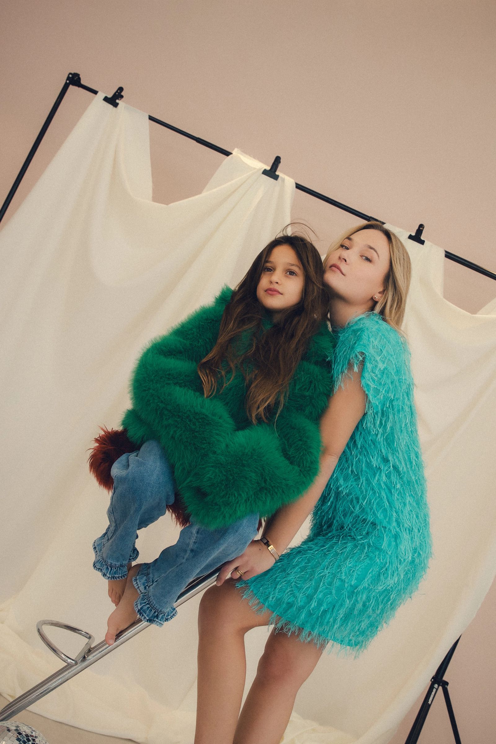 Moeder en dochter in groene en turquoise fluffy outfits in de studio